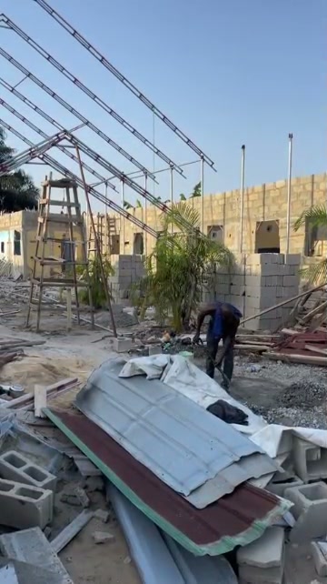 Worker among building materials and roof framing