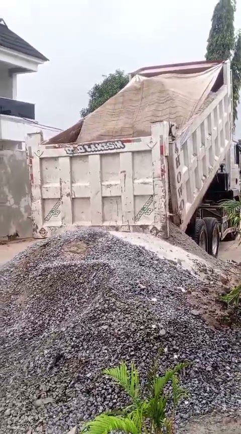 A truck delivering gravel to the church building project