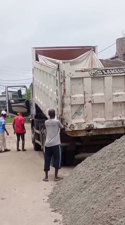 Workers beside a gravel delivery truck